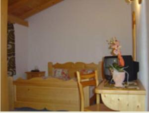 a room with a table and a desk with a tv at Hotel Cristallina in Sils Maria