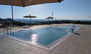 a swimming pool with umbrellas on a building at Vivienda de Uso Turístico Doña Urraca in Fermoselle