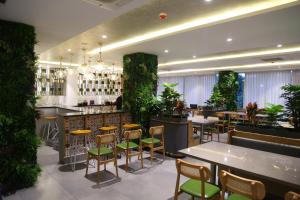 a restaurant with tables and chairs and plants at Roots Luxury suits & Banquets in Bangalore
