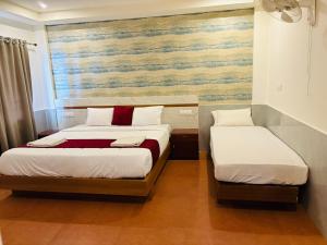 a bedroom with two beds and a painting on the wall at Shola Heaven Resort in Kanthalloor +3 photos