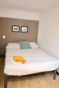 a large white bed with an orange towel on it at Habitación privada en Polanco cerca del Metro in Mexico City