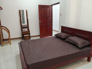 a bedroom with a large bed and a wooden door at Pacifier Residence in Kandy