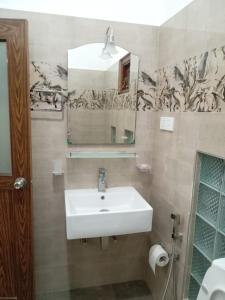 a bathroom with a white sink and a mirror at Pacifier Residence in Kandy +24 photos
