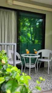 Un patio con dos sillas y una mesa con dos cuencos encima. en Cozy The Title Residencies, en Nai Yang Beach