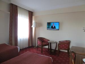 Habitación de hotel con cama, mesa y sillas en Ozilhan Hotel, en Ankara