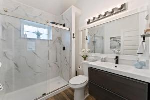 a bathroom with a shower and a toilet and a sink at 212 E Toledo Ave in Wildwood Crest +29 photos