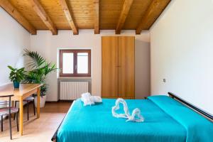 een slaapkamer met een blauw bed en een houten plafond bij Camping Monja in Brenzone sul Garda