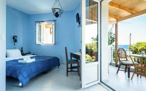 - une chambre avec un lit, une table et un balcon dans l'établissement Villa Eliza, à Skála Kefalonias