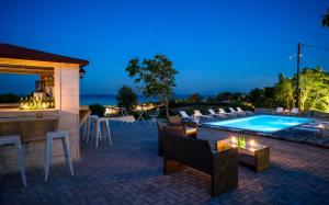 a patio with a bar and a swimming pool at Villa Eliza in Skala