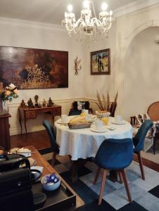 a dining room with a table and a chandelier at La Maison d'Adèle in Neufchâteau
