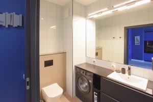 Un baño con lavadora y lavabo. en VacationClub - Let's Sea Baltic Park Apartament F96, en Gąski 6 fotos más