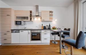 ペルトシャッハ・アム・ヴェルターゼーにあるFerienwohnung Pörtschach 52M²の白いキャビネットとテーブルと椅子のあるキッチン