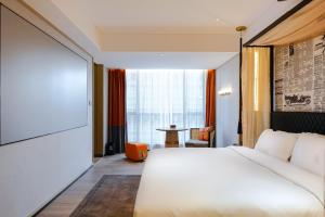 广州Arthur Hotel Baiyun Guangzhou的卧室里有一张白色的大床和一张桌子 更多37张照片