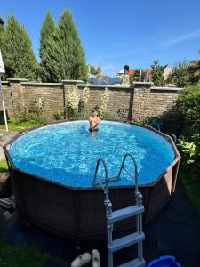 a boy in a swimming pool in a bath tub at Pensjonat Lemon in Pobierowo