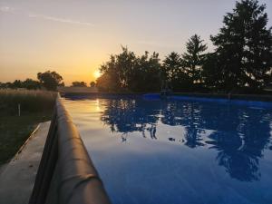 AntignyにあるMa Pause Champêtreの夕日を背景にしたプール