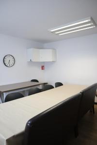 a conference room with tables and chairs and a clock at Hermosa Habitación con balcon cama mat y litera Polanco in Mexico City