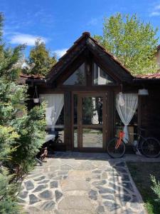 a house with a bike parked outside of it at Kalaydzhiev Guest House - Къща с 5 спални in Bansko