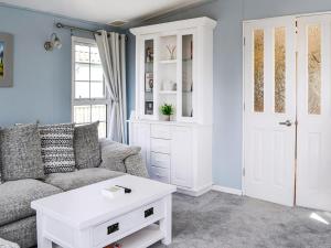 a living room with a couch and a coffee table at Sunnyside Lodge in Monreith