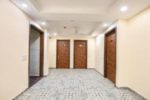 an empty corridor with wooden doors in a building at FabHotel Angel Pink The Premium in Ghaziabad +20 photos