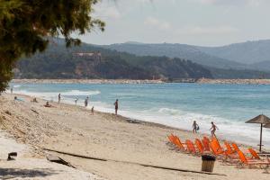 een groep mensen op een strand met stoelen en de oceaan bij Villa Fun & Sun in Limenaria