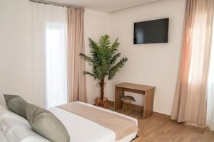 a living room with a white couch and a plant at Viroga Suite Apartments in Castel Volturno