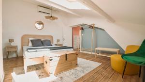 a bedroom with a bed and a yellow chair at Le Tonnelier Chalon in Chalon-sur-Saône