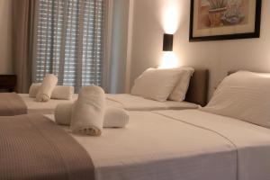 zwei Betten in einem Zimmer mit weißen Laken und Kissen in der Unterkunft Therma Hotel in Loutra Ipatis + 51 Fotos