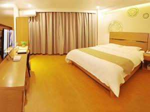 a bedroom with a bed and a desk and a television at GreenTree Inn Fuzhou Eastern Capital Express Hotel in Shiliting