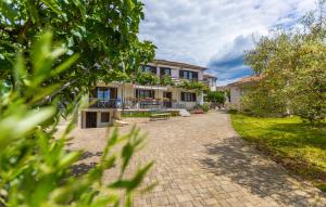 a house with a brick driveway in front of it at 3 Bedroom Cozy Apartment In Malinska in Malinska +21 photos