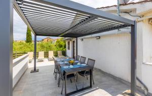 a patio with a table and chairs under a pergola at 3 Bedroom Cozy Apartment In Malinska in Malinska
