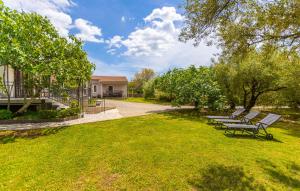 a group of benches sitting in a park at 3 Bedroom Cozy Apartment In Malinska in Malinska