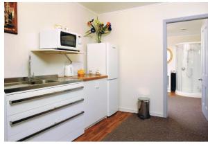 a white kitchen with a sink and a microwave at Pelorus Heights in Havelock