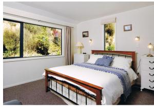 a bedroom with a bed and a large window at Pelorus Heights in Havelock