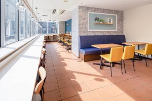 a dining room with tables and chairs and windows at Comfort Hotel Narita in Narita