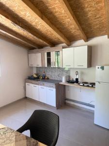 a kitchen with white cabinets and a black chair at The Brothers Villa in Ohrid
