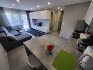 a living room with a table with flowers on it at Apartamenty Kacper Grzybowo in Grzybowo
