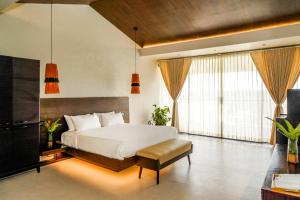 a bedroom with a white bed and a large window at Virgin Valley Leisure Resort in Ooty