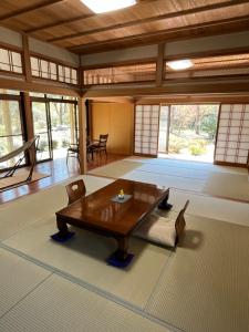 a living room with a wooden table in a room at 杜の宿 らくう庵 山鹿 in Yamaga