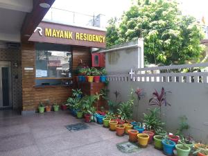 Un montón de plantas en macetas frente a un restaurante. en Mayank Residency, en Dehradun