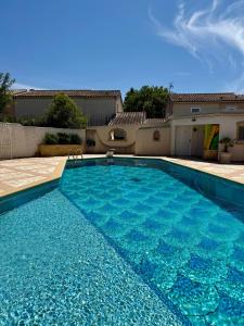 a large blue swimming pool in front of a house at Villa Victoire au coeur de la Provence in Venelles