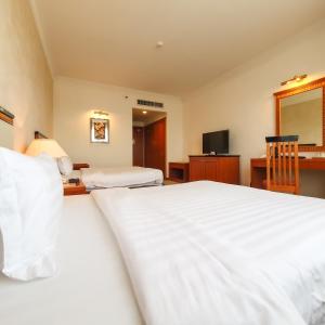 a hotel room with two beds and a television at Parkview Hotel in Kampong Jerudong