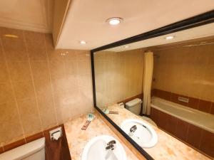 a bathroom with a sink and a toilet and a mirror at Parkview Hotel in Kampong Jerudong