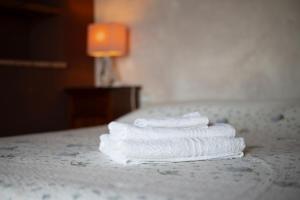 three towels stacked on a bed in a hotel room at Casale Poggio Rocco in Manciano +17 photos