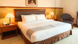 a large bed in a hotel room with two lamps at Parkview Hotel in Kampong Jerudong