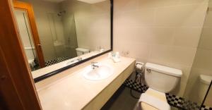 a bathroom with a sink and a toilet and a mirror at Parkview Hotel in Kampong Jerudong