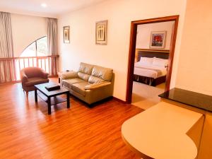 a living room with a couch and a bed at Parkview Hotel in Kampong Jerudong