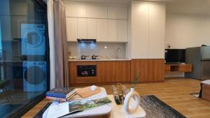 a living room with a table with books and a kitchen at The West Lake Serenity'N Homestay Ha Noi 462 in Hanoi