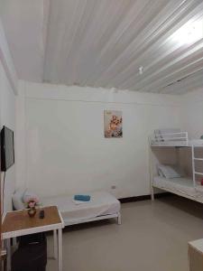 a room with two beds and a table in it at RedDoorz at Wyns Hotel in Silañgang Mayao +12 photos