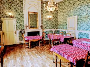 a restaurant with pink tables and chairs and a chandelier at Domaine de Launay blot in Baguer-Morvan