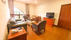 a living room with a couch and a television at Parkview Hotel in Kampong Jerudong